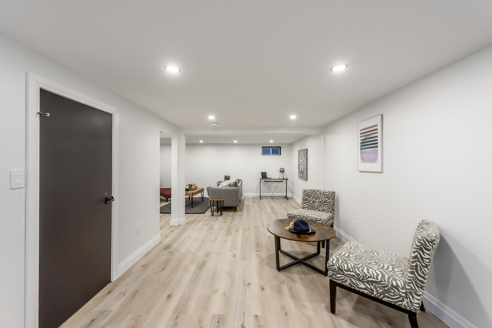 Professional finished basement with excellent lighting and staging — premium portfolio shot showing complete transformation — Gateshead, Hamilton | MTC Renovations
